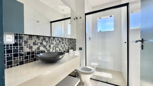a bathroom with a bowl sink and a toilet at Ariana Apart Hotel Canasvieiras in Florianópolis