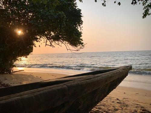 a boat sitting on a beach with the ocean at Villa Ebouye in Kribi