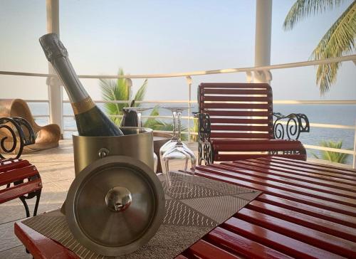 克里比的住宿－Villa Ebouye，甲板上的桌子和一瓶葡萄酒