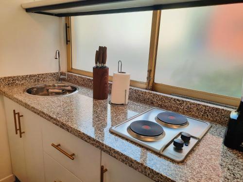 a kitchen counter with a stove and a sink at Apartamento con terraza privada junto al Bulevar del Rio in Cali