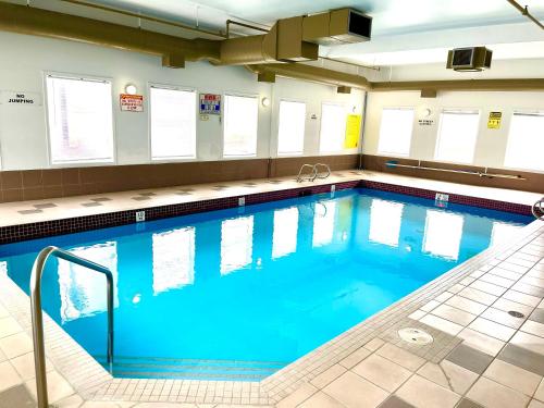 a large swimming pool with blue water at Super 8 by Wyndham Hinton in Hinton