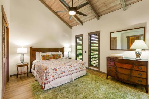a bedroom with a bed and a dresser and a mirror at Waikomo Stream Villas 332 in Koloa
