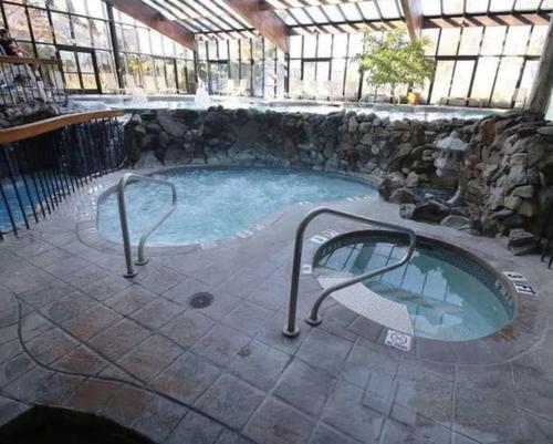 bañera de hidromasaje en un edificio con pared de piedra en 10 guest Ski Chalet Pools Golf Ski Hike, en Vernon Township