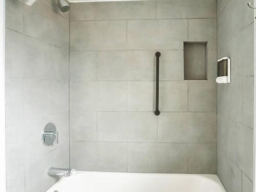 y baño con ducha y bañera blanca. en Updated Spacious Home Near Northwestern University, en Wilmette