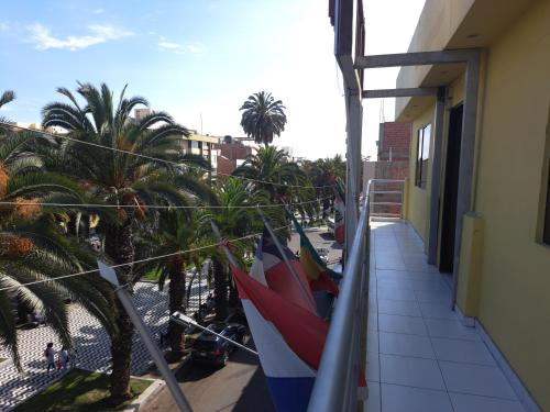 a balcony with palm trees and flags on a building at Hotel Residencial C´BASTIAN in Tacna