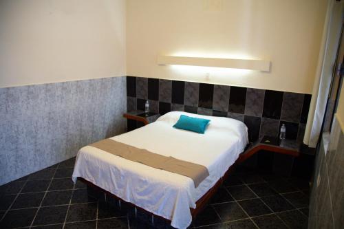 a bedroom with a bed with a blue pillow on it at Privada Guadalupe in Monterrey