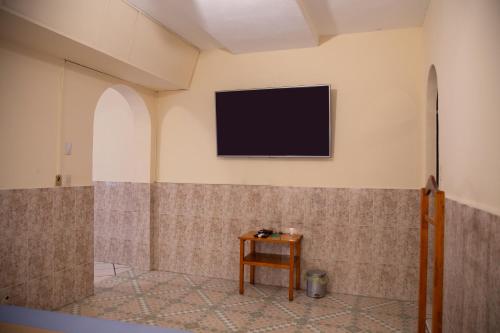 a television on the wall of a room with a table at Privada Guadalupe in Monterrey