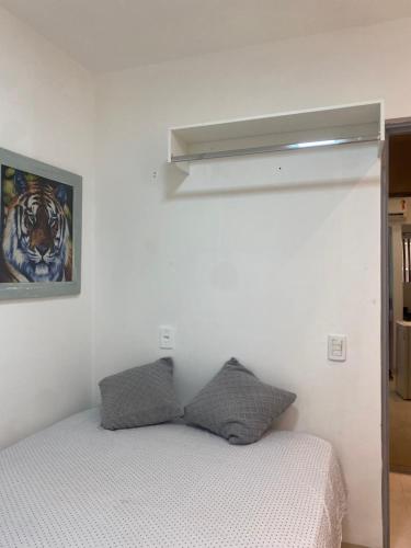 Suítes flat mobiliados com área de lazer picina في أراغوينا: غرفة نوم بسرير ودهان على الحائط