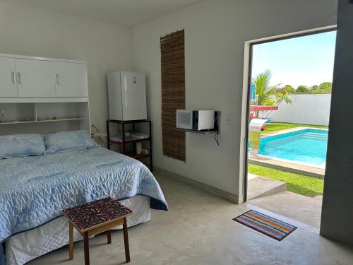 a bedroom with a bed and a view of a pool at Suíte aconchegante com delicioso café da manhã in Porto Seguro