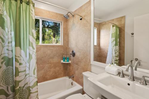 uma casa de banho com um lavatório, uma banheira e um WC. em Kauai Bay House, Ocean Front em Koloa