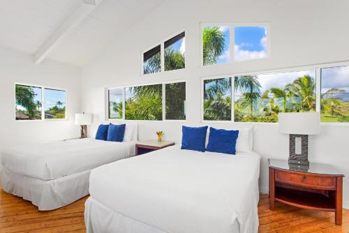 Duas camas e um sofá num quarto com janelas em Kauai Bay House, Ocean Front em Koloa