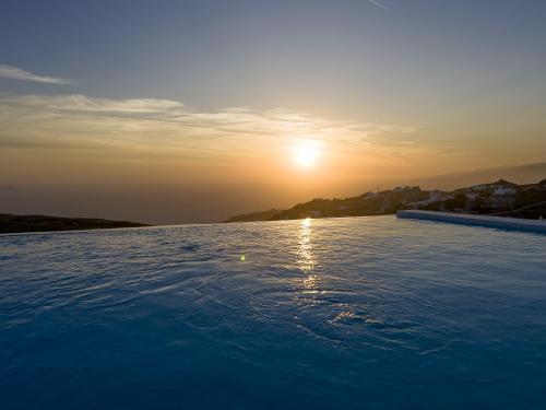 una gran piscina de agua con el sol en el cielo en Villa Prive 88 Mykonos, en Fanari