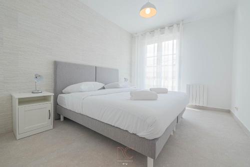 une chambre blanche avec un grand lit et une fenêtre dans l'établissement *Disneyland-Paris*4pers, Wifi, Parking, à Serris