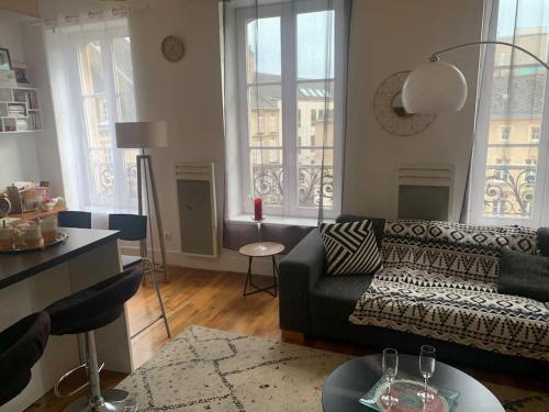 a living room with a couch and two windows at Appartement DuplexCœur de Ville in Metz