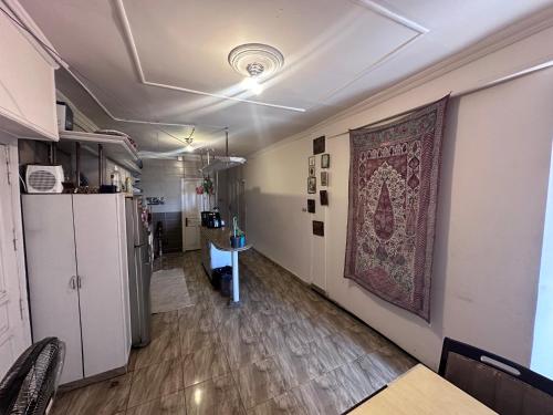 a room with a rug on the wall and a refrigerator at Haidar House a private rooms for men only at shared apartment غرف خاصه للرجال فقط in Alexandria