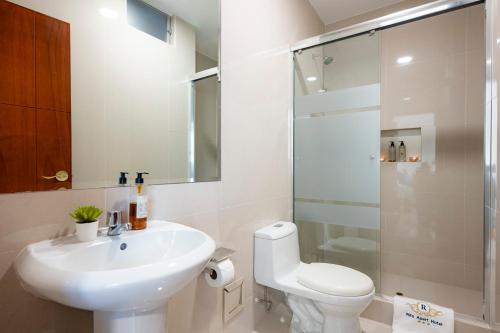 een badkamer met een wastafel, een toilet en een douche bij Rits Apart Hotel in Lima