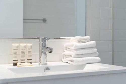 a pile of towels sitting on a bathroom sink at Stylish 1BR Haven in Bondi Junction in Sydney