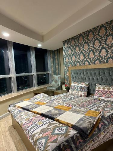 um quarto com uma cama grande e janelas em Islamabad lodges apartment suite em Islamabad