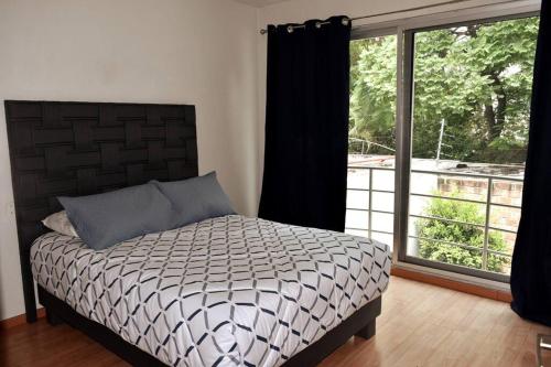 a bedroom with a bed and a large window at Valentin House, very spacious and cozy. in San Luis Potosí