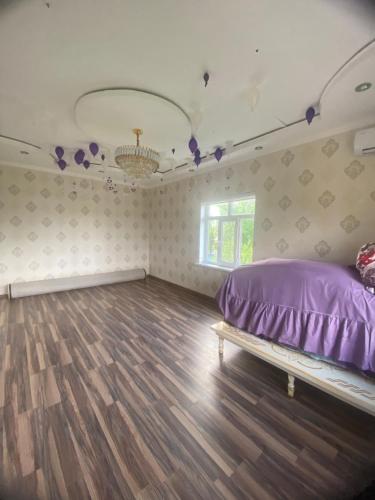 にあるGardenの紫色のベッドが備わるウッドフロアの客室です。