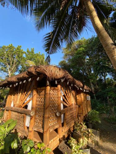 a small wooden hut with a thatched roof at Eco Park - Albur Rental Properties in Alburquerque