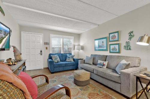 a living room with a gray couch and a blue chair at La Casita at Surfside 103 in South Padre Island