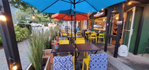 a restaurant with tables and chairs and an umbrella at Harrison Spa Motel in Harrison Hot Springs
