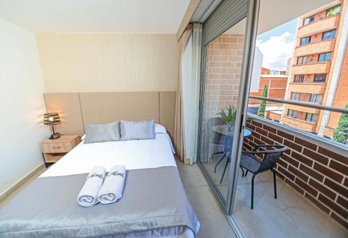 ein Schlafzimmer mit einem Bett und einem Balkon in der Unterkunft Apartamentos Montecarlo in Medellín