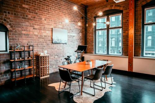 a dining room with a brick wall and a table and chairs at Massive Downtown Seattle Condo - Free Parking! in Seattle
