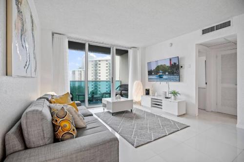 Great Apartment with beach access في هوليوود: غرفة معيشة مع أريكة ونافذة كبيرة