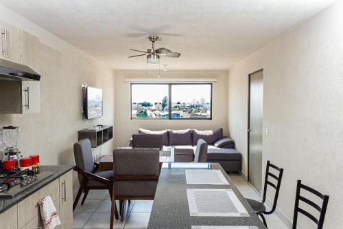 a kitchen and living room with a couch and a table at Central condominium near IMSS, H Civil & CUCS in Guadalajara
