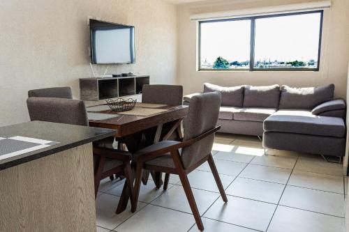 a living room with a table and a couch at Central condominium near IMSS, H Civil & CUCS in Guadalajara