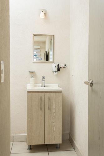 a bathroom with a sink and a mirror at Central condominium near IMSS, H Civil & CUCS in Guadalajara