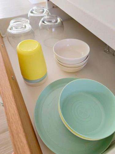 a counter top with bowls and plates on it at Kiddie Hostel Unit30A-kids and pets friendly in Subic bay freeport zone in Kababae