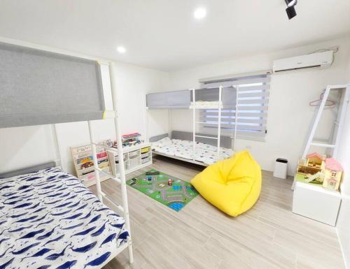 a bedroom with a bunk bed and a yellow chair at Kiddie Hostel Unit30A-kids and pets friendly in Subic bay freeport zone in Kababae