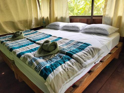 a bed with two hats and towels on it at Amazon Jaguar Adventure & Lodge in Iquitos