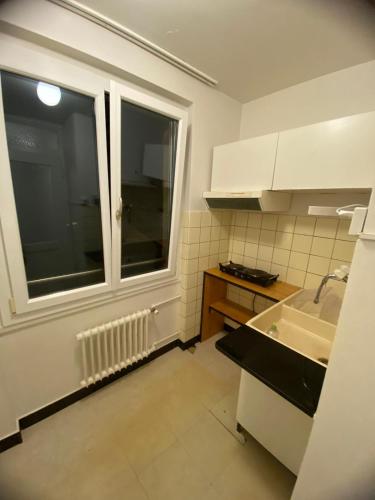 una pequeña cocina con ventana y fregadero en Chambre a Neuchâtel en Neuchâtel