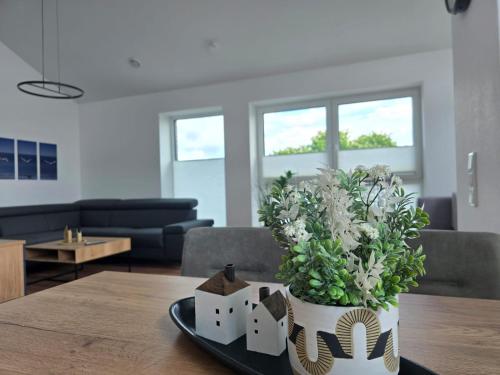 a vase of flowers on a table in a living room at Ferienwohnung Emil in Norden
