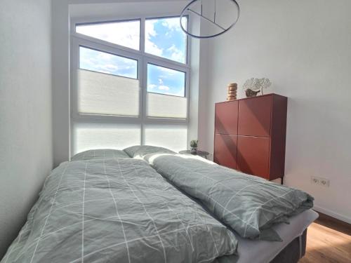 a bed in a bedroom with a large window at Ferienwohnung Emil in Norden