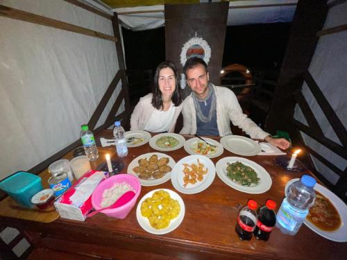 a man and woman sitting at a table with food at Cakrawala Borneo Tour Tanjung puting in Kumai