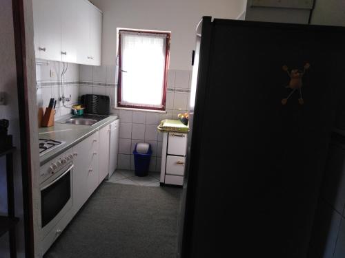 a kitchen with a black refrigerator and a window at Holiday house with a parking space Srijane, Zagora - 22621 in Smoljanovići