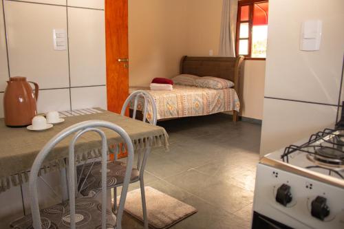 eine kleine Küche mit einem Tisch und einem Kühlschrank in der Unterkunft Pousada Chalés Além do Paraíso in Alto Paraíso de Goiás