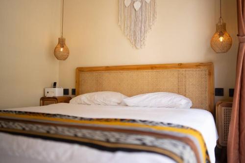 a bedroom with a bed with two pillows at Villa Benih Uluwatu in Jimbaran