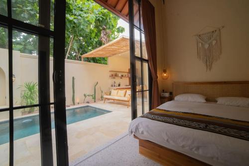a bedroom with a bed and a swimming pool at Villa Benih Uluwatu in Jimbaran