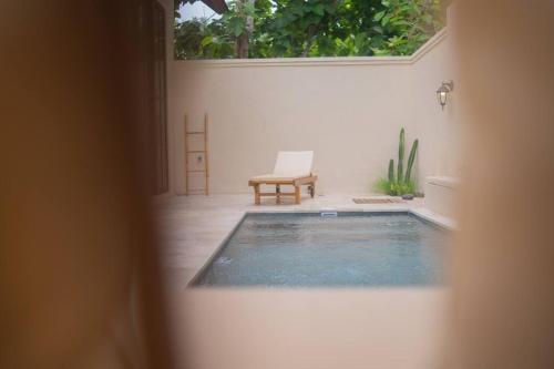 a view of a swimming pool with a chair in a courtyard at Villa Benih Uluwatu in Jimbaran