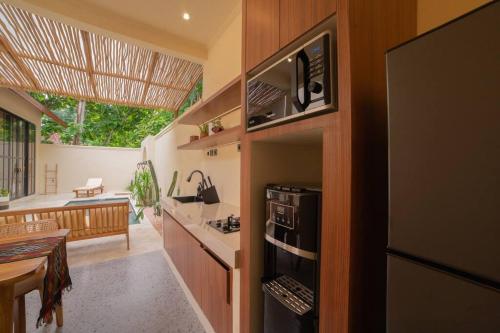 a kitchen with a refrigerator and a stove top oven at Villa Benih Uluwatu in Jimbaran
