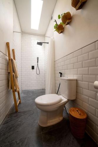 a bathroom with a white toilet and a shower at Villa Benih Uluwatu in Jimbaran