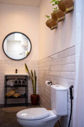 a bathroom with a white toilet and a mirror at Villa Benih Uluwatu in Jimbaran