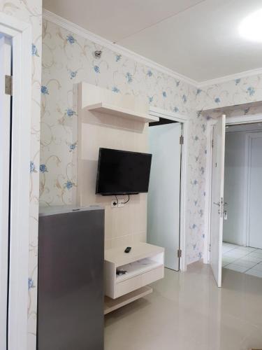 ein Wohnzimmer mit einem Flachbild-TV an der Wand in der Unterkunft Apartemen Green Pramuka City Type 2BR Full Furnish in Jakarta