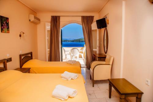 a hotel room with two beds and a window at Hotel Niras in Nydri